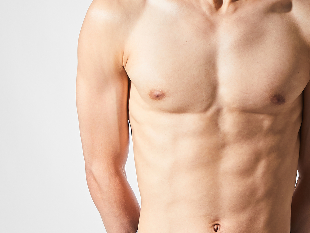Shirtless man displays a flat, toned chest after gynecomastia surgery Shirtless man displays a flat, toned chest after gynecomastia surgery